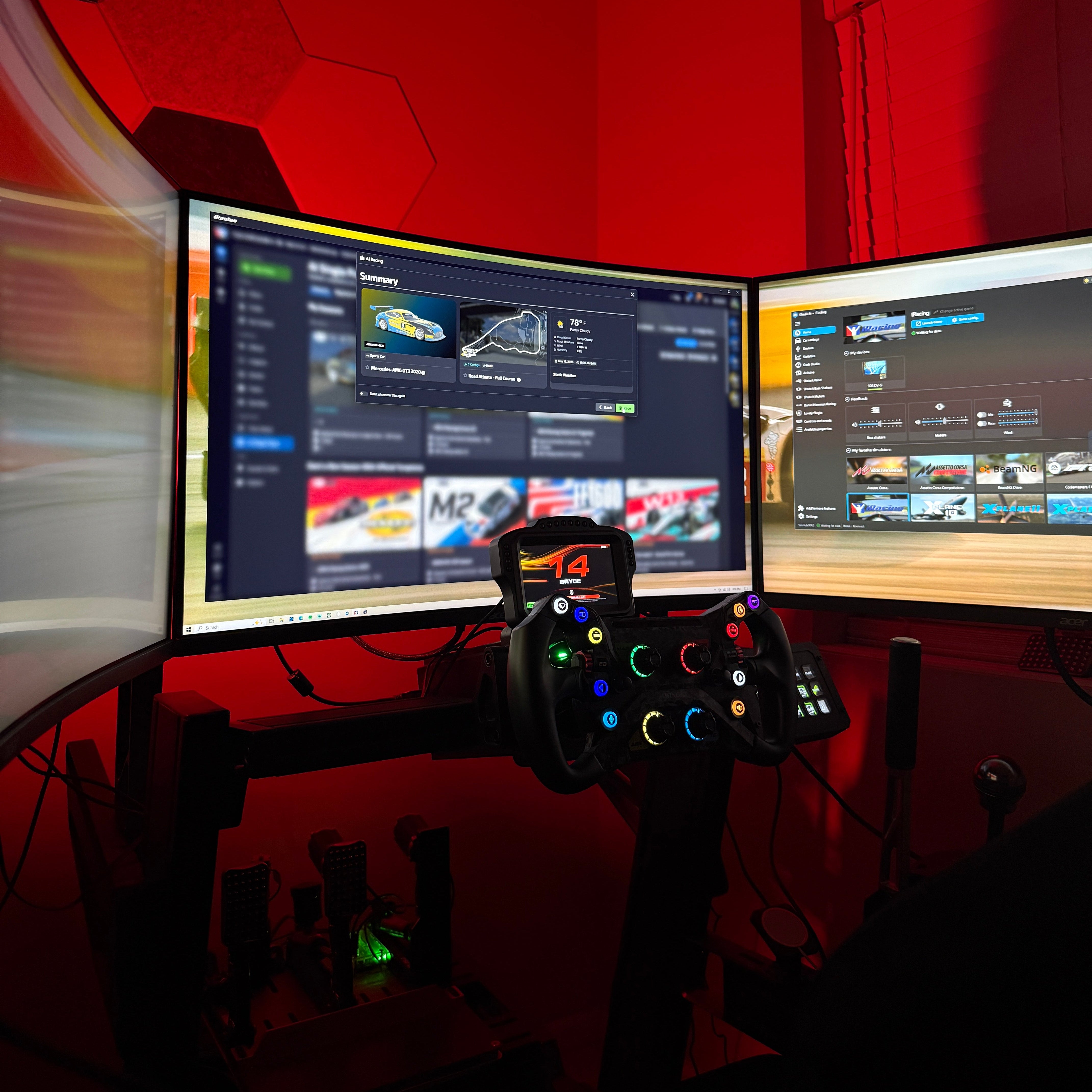 Gaming setup with dual monitors and a joystick on a red wall background